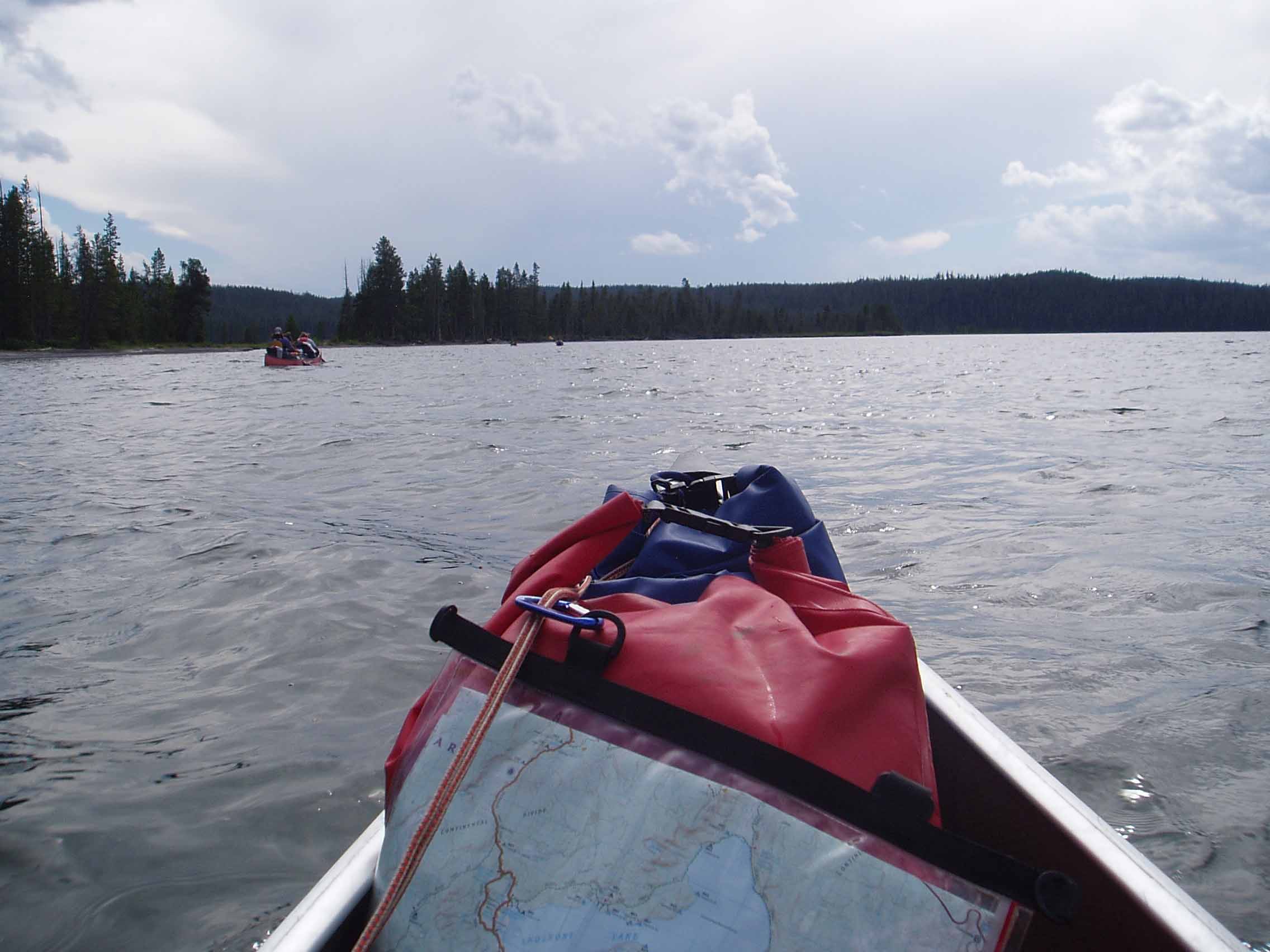 A red and white boat sitting next to a body of water

Description automatically generated