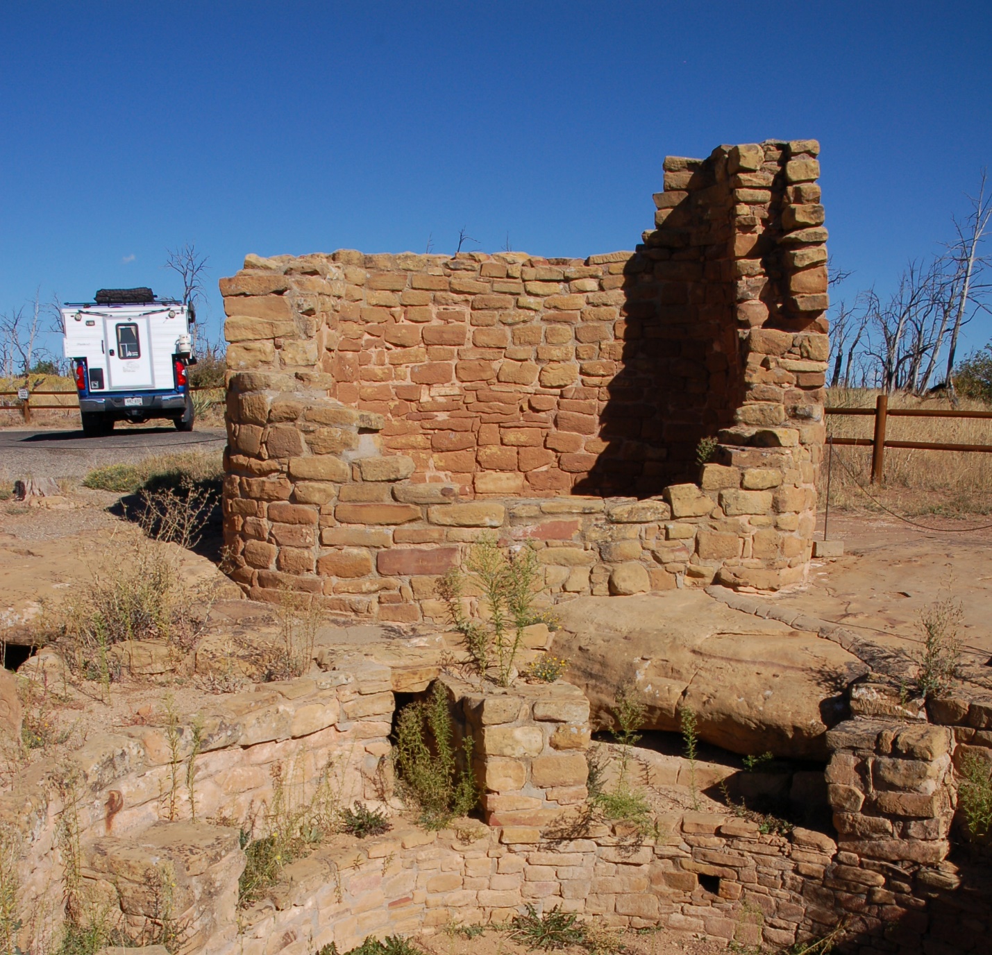 A stone building with a mountain in the background
Description automatically generated