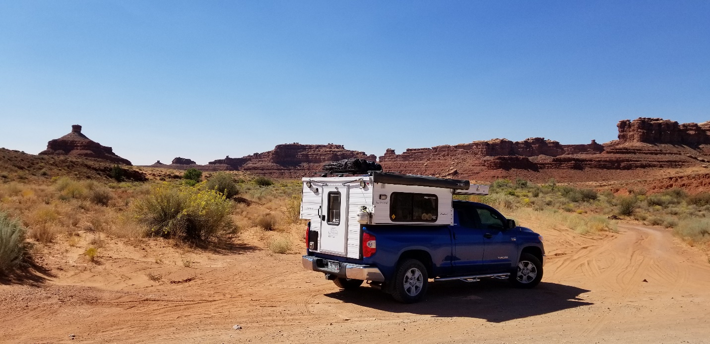 A truck driving down a dirt road

Description automatically generated