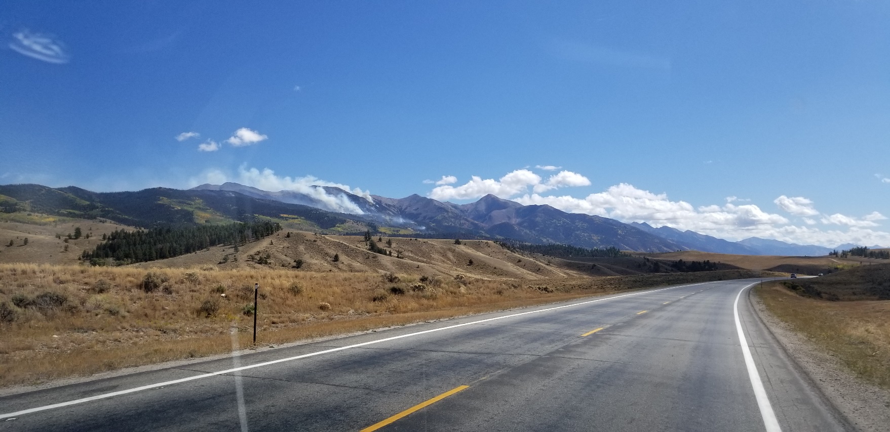 An empty road with a mountain in the background

Description automatically generated